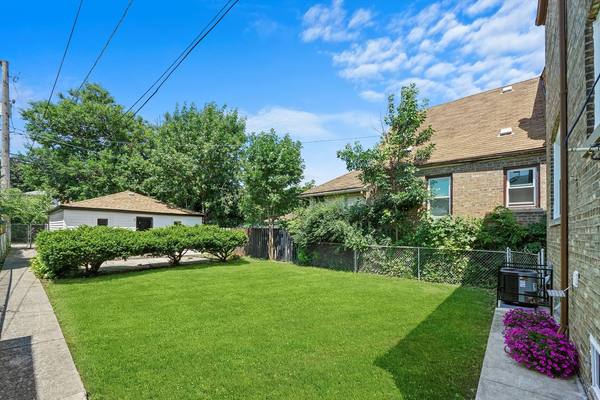 Rear elevation, masonry and fence line rebuilt. The housing stock in South Shore is mostly brick two-flats.